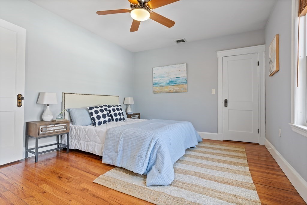 132 Rawson Road, Unit 132 Arlington, MA 02474 - Photo 19 of 26 a bedroom with a bed wooden floor and window