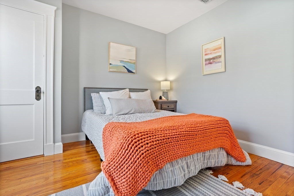 132 Rawson Road, Unit 132 Arlington, MA 02474 - Photo 24 of 26 a bedroom with a bed and wooden floor