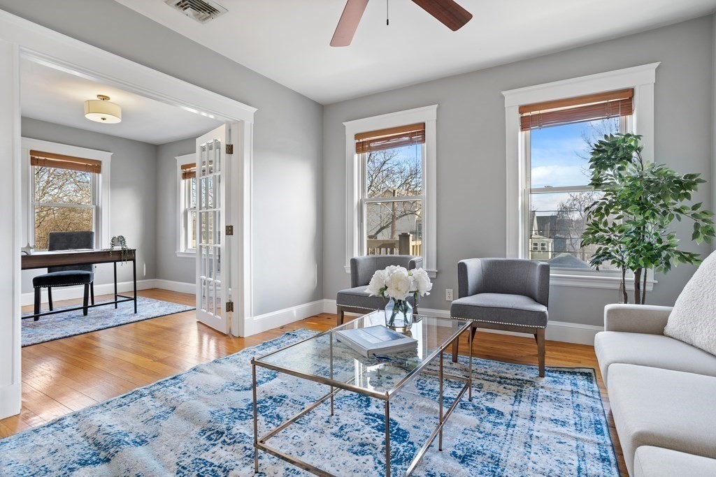 132 Rawson Road, Unit 132 Arlington, MA 02474 - Photo 4 of 26 a living room with patio furniture and a wooden floor