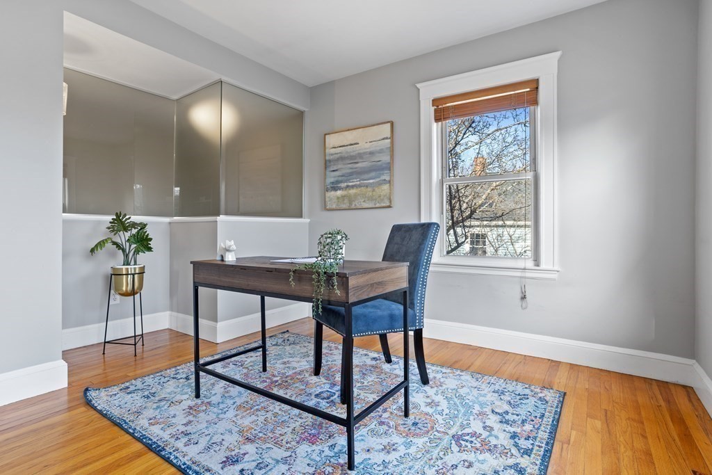 132 Rawson Road, Unit 132 Arlington, MA 02474 - Photo 6 of 26 a workspace with furniture and wooden floor