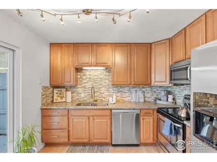 a kitchen with stainless steel appliances granite countertop a refrigerator a sink a stove and cabinets