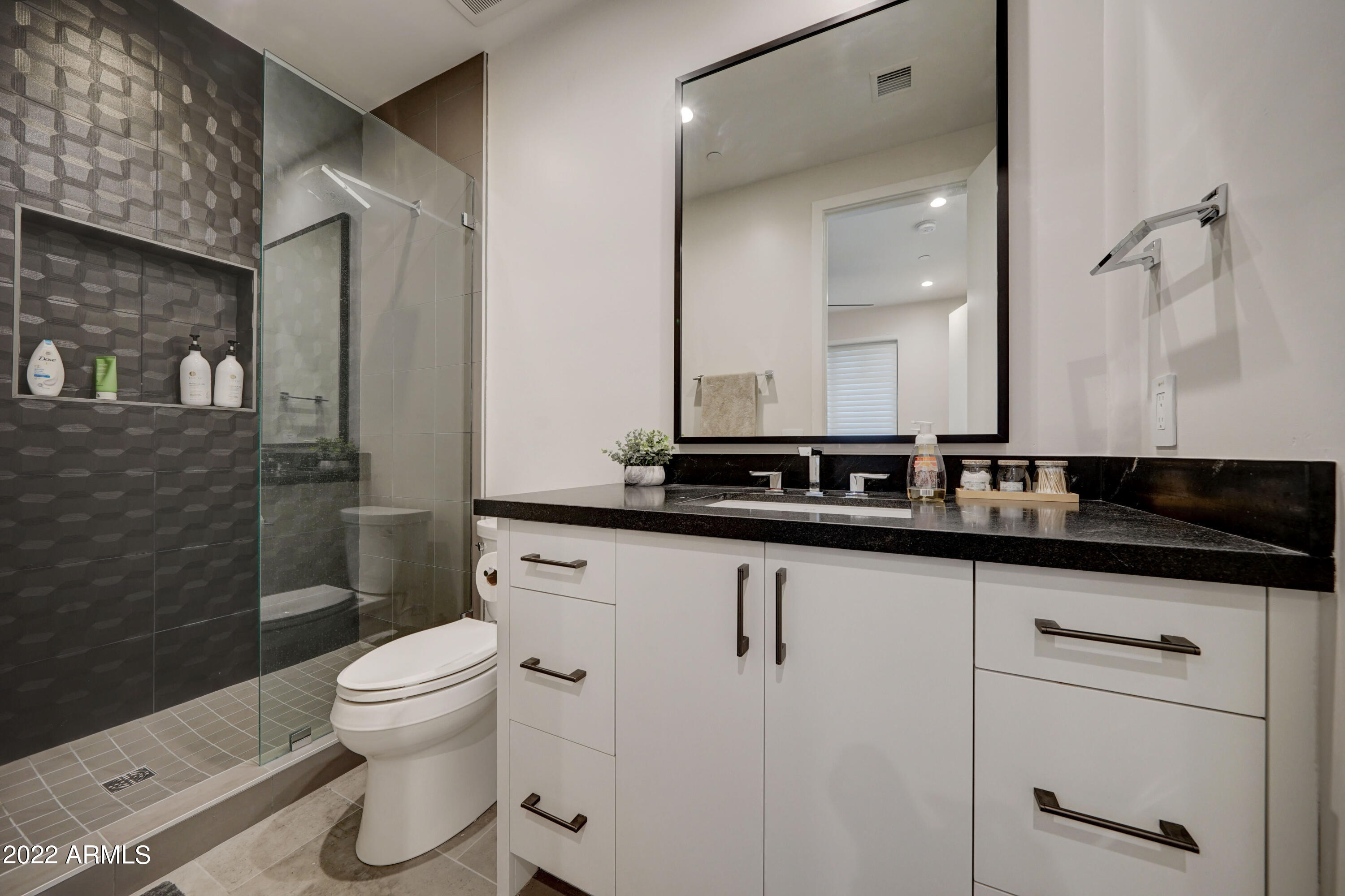 6500 East Camelback Road, Unit 1006 Scottsdale, AZ 85251 - Photo 16 of 38 a bathroom with a sink a toilet a mirror and shower