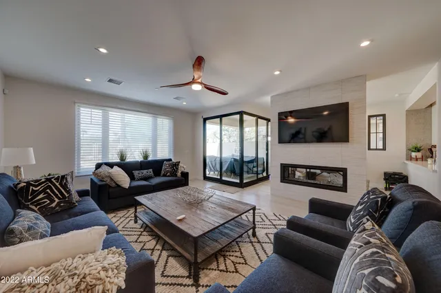 a living room with furniture ceiling fan and a wooden floor
