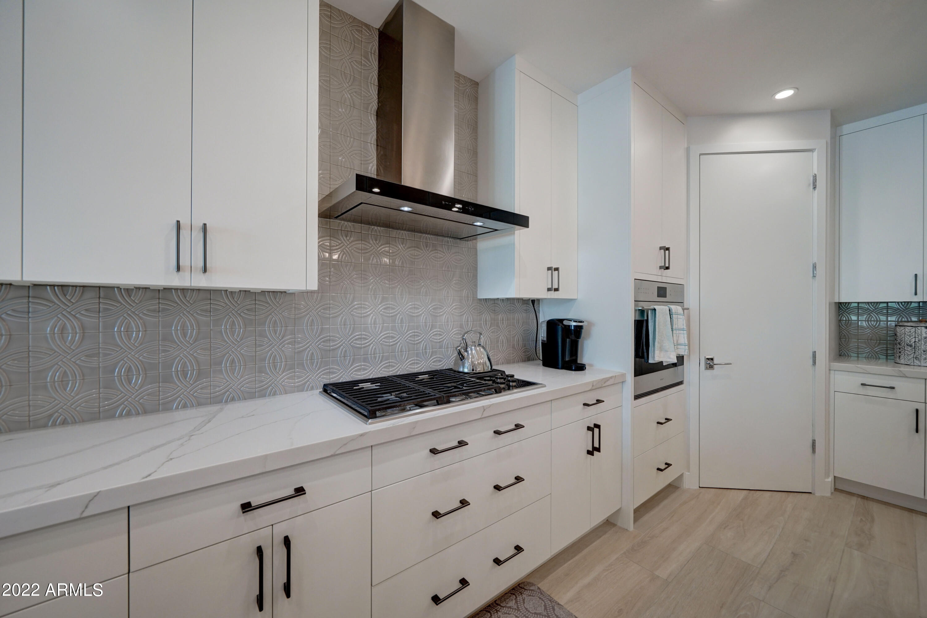 6500 East Camelback Road, Unit 1006 Scottsdale, AZ 85251 - Photo 10 of 38 a kitchen with white cabinets and appliances