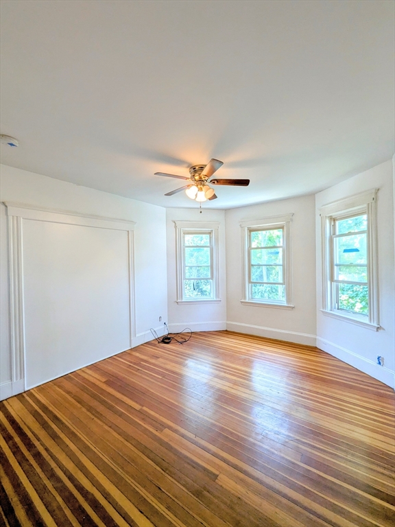 84 Bailey Street Boston, MA 02124 - Photo 3 of 11 a view of an empty room with wooden floor and a window