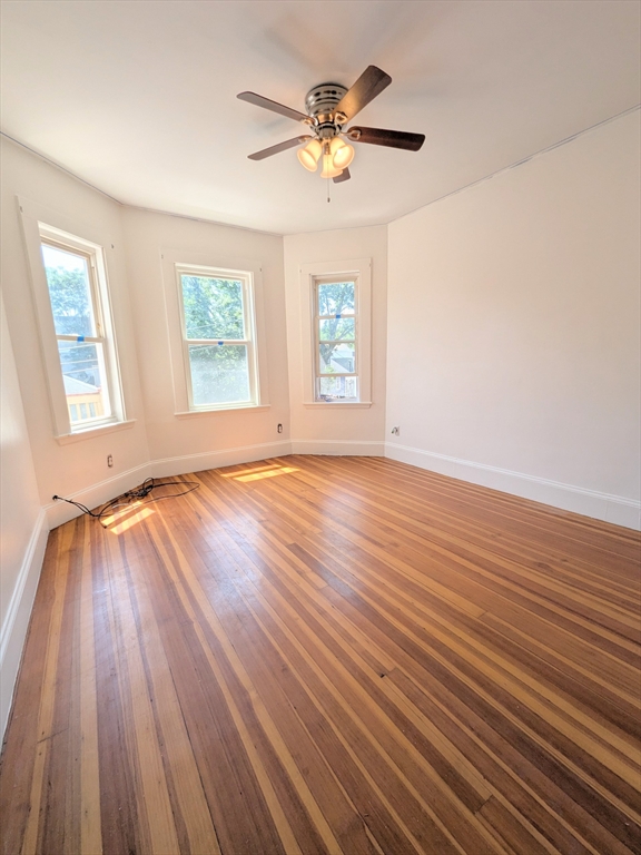 84 Bailey Street Boston, MA 02124 - Photo 5 of 11 an empty room with wooden floor and windows
