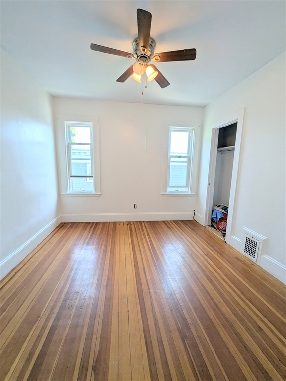 84 Bailey Street Boston, MA 02124 - Photo 6 of 11 an empty room with wooden floor and windows
