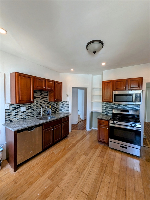 84 Bailey Street Boston, MA 02124 - Photo 8 of 11 a kitchen with stainless steel appliances kitchen island granite countertop a stove and a wooden floors
