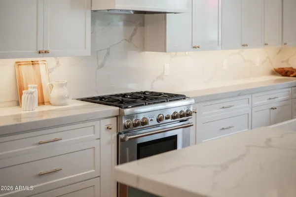 a kitchen with granite countertop white cabinets and white stove