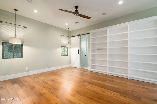 a view of an empty room with a window and wooden floor