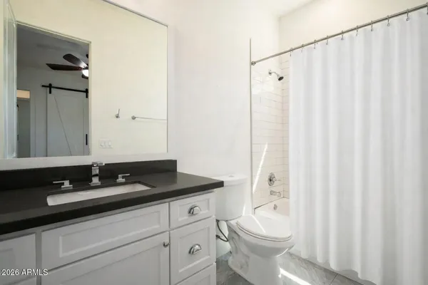 a bathroom with a granite countertop sink toilet and shower