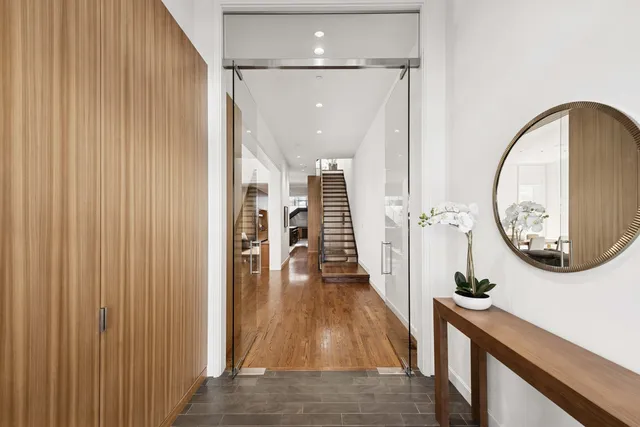 a view of a hallway with wooden floor and front door