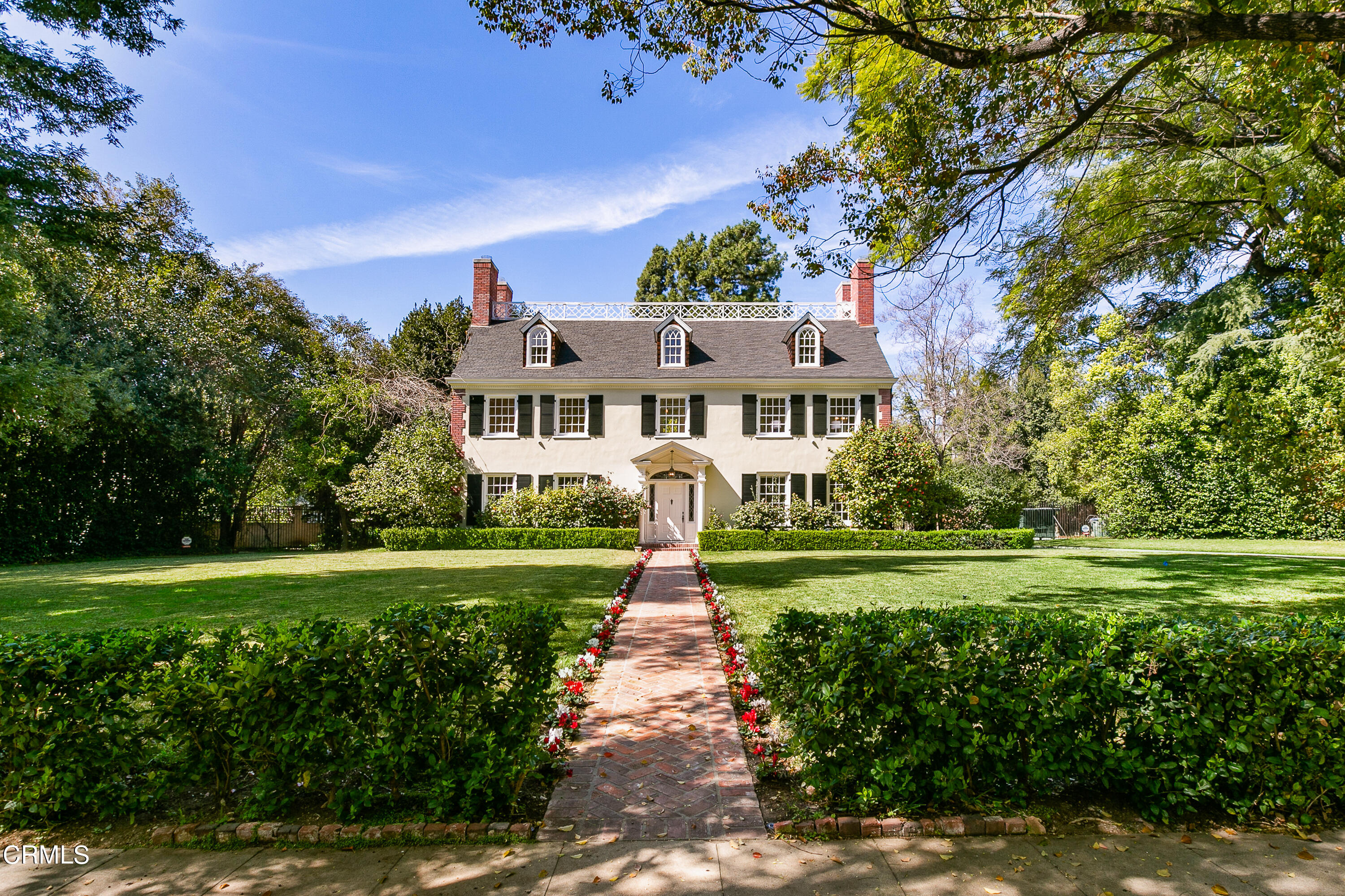 a front view of a house with a yard and trees