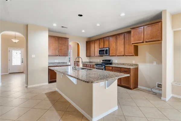 a kitchen with a sink a stove a refrigerator and cabinets