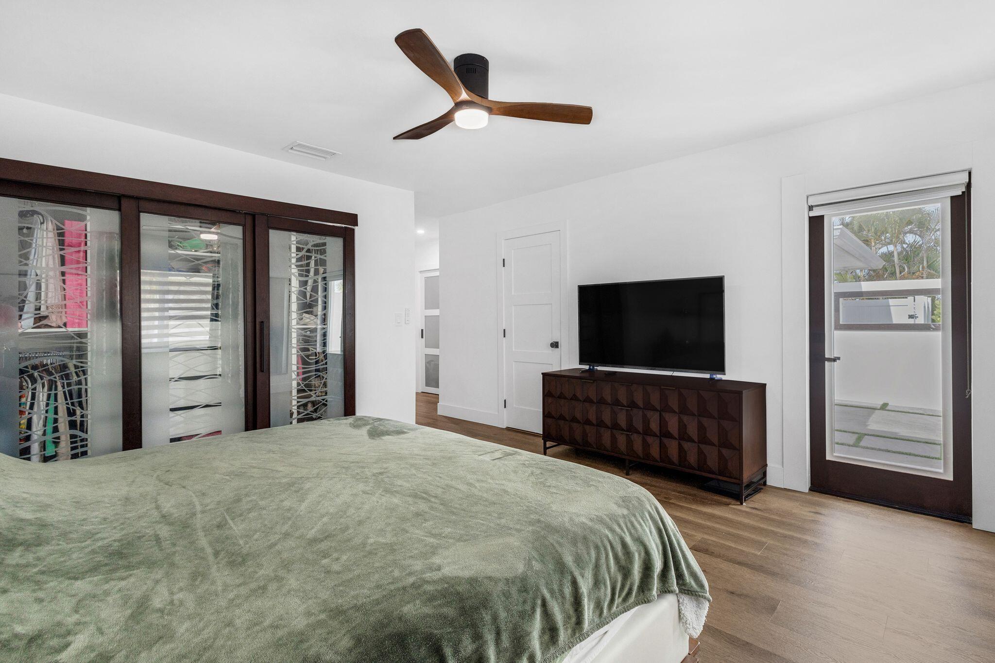 226 Bamboo Road Palm Beach Shores, FL 33404 - Photo 14 of 39 a bedroom with a bed and a flat tv screen on dresser
