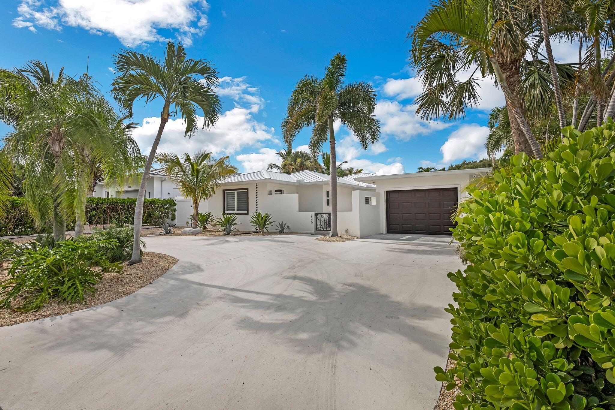 226 Bamboo Road Palm Beach Shores, FL 33404 - Photo 2 of 39 a view of a house with a yard and palm trees