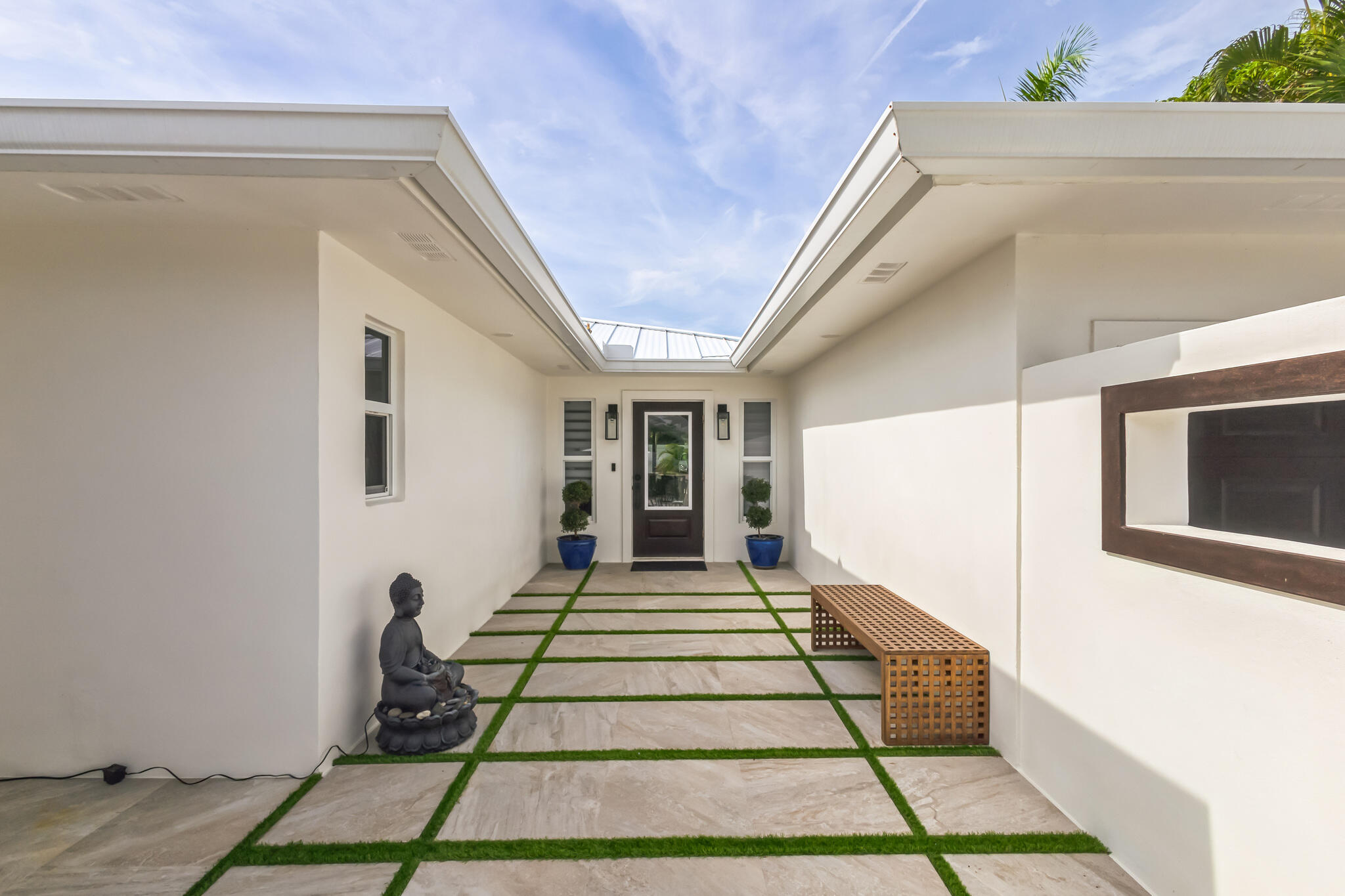 226 Bamboo Road Palm Beach Shores, FL 33404 - Photo 3 of 39 a front view of a house with a porch