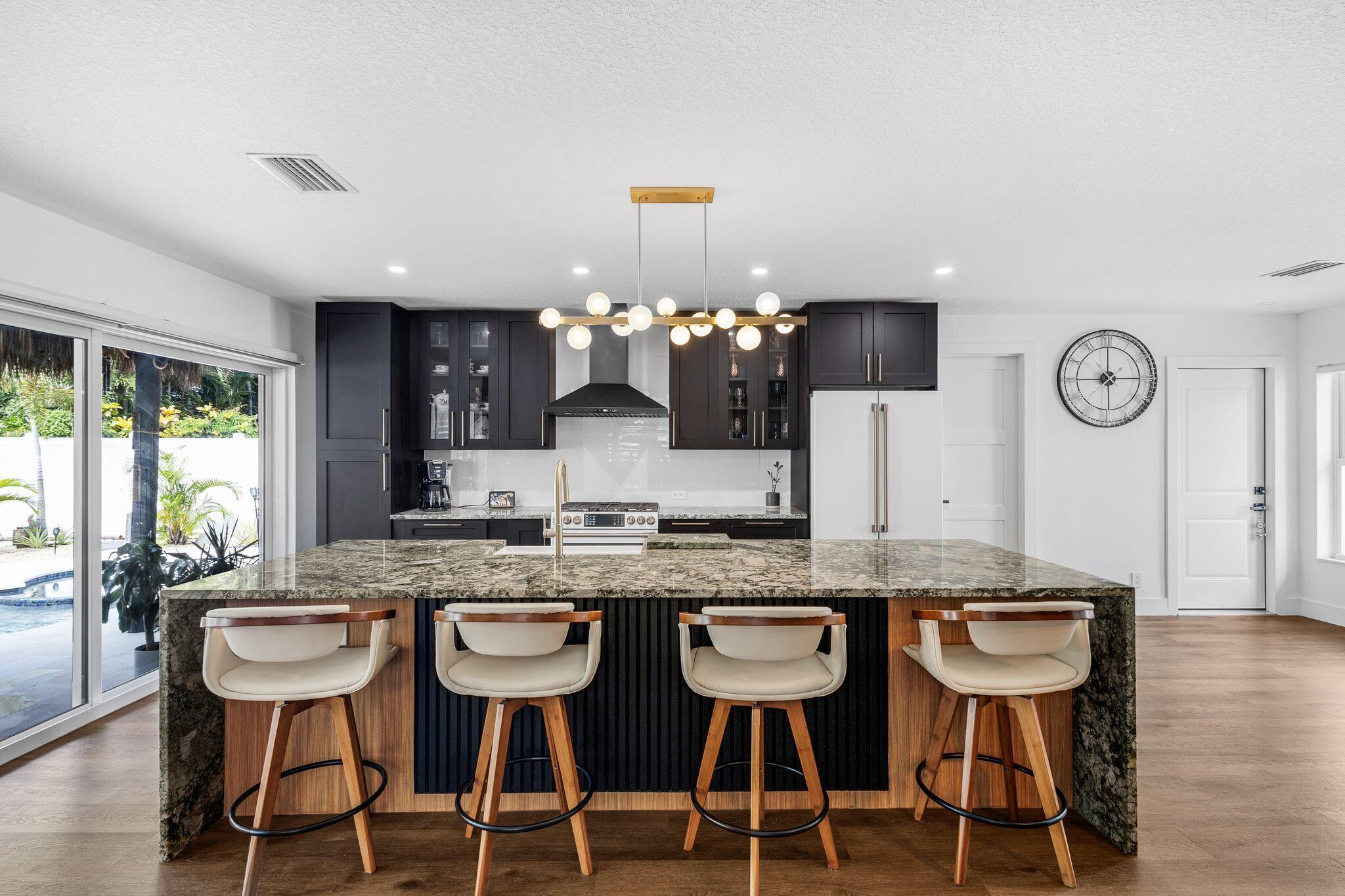 226 Bamboo Road Palm Beach Shores, FL 33404 - Photo 7 of 39 a kitchen with cabinets counter and chairs