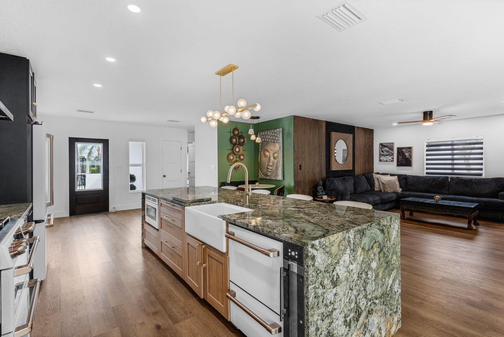 226 Bamboo Road Palm Beach Shores, FL 33404 - Photo 8 of 39 a large white kitchen with kitchen island a stove a sink a oven and a dining table