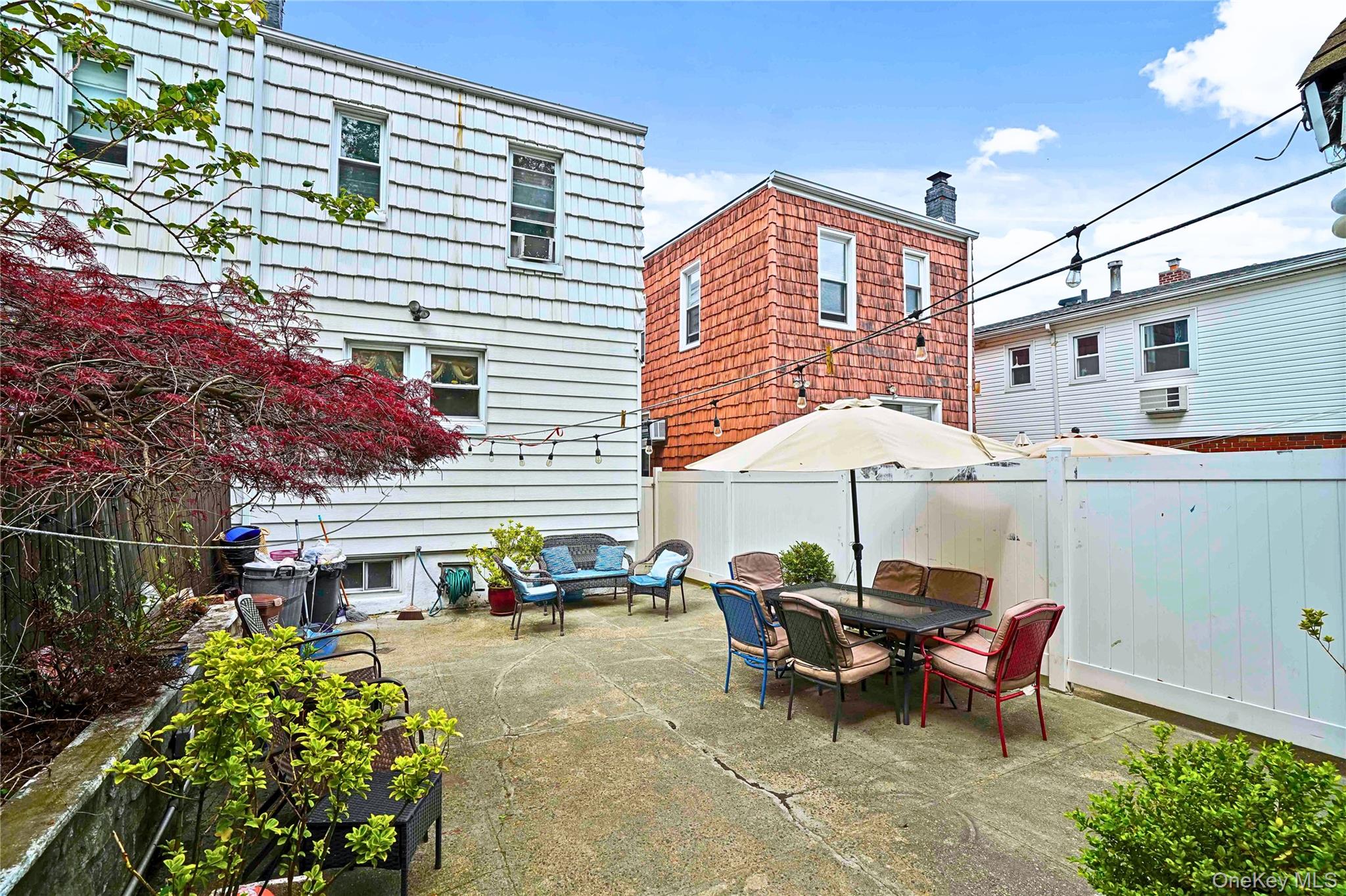 59-11 Fresh Pond Road Queens, NY 11378 - Photo 16 of 18 a view of a patio with table and chairs under an umbrella