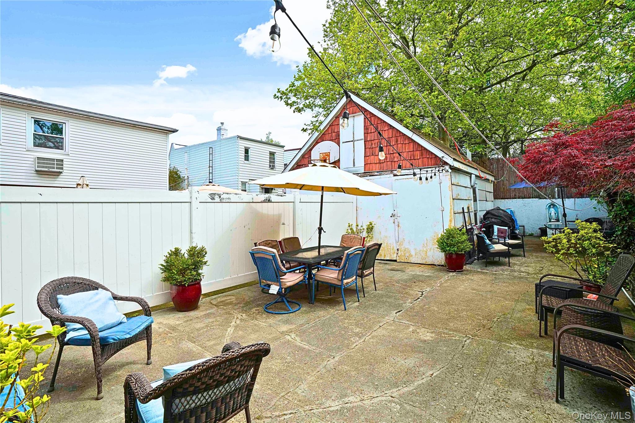 59-11 Fresh Pond Road Queens, NY 11378 - Photo 17 of 18 a patio with a table and chairs under an umbrella
