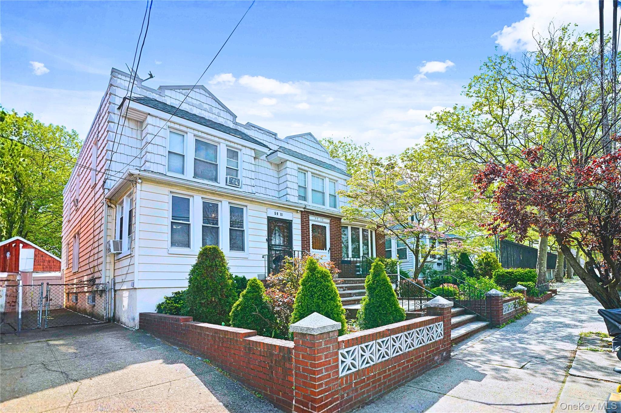 59-11 Fresh Pond Road Queens, NY 11378 - Photo 2 of 18 a front view of a house with garden and sitting area