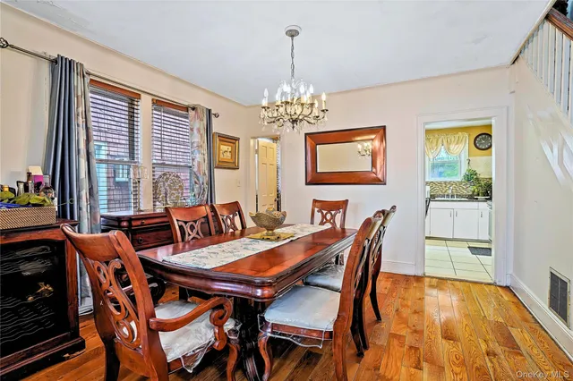 a view of a dining room with furniture a chandelier and wooden floor