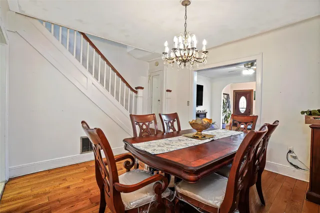 a view of a dining room with furniture a chandelier and wooden floor