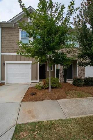 a front view of a house with a yard and a garage