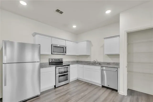 a view of kitchen with refrigerator and wooden floor