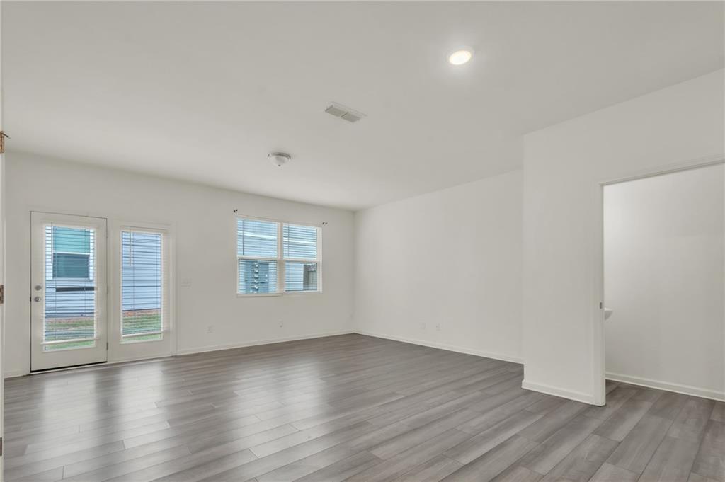 1517 Vernon Boulevard Decatur, GA 30035 - Photo 6 of 25 an empty room with wooden floor and windows
