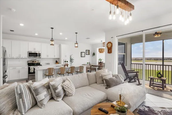 a living room with furniture white walls and a large window