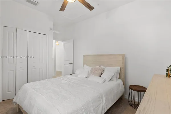 a bedroom with a bed and a ceiling fan