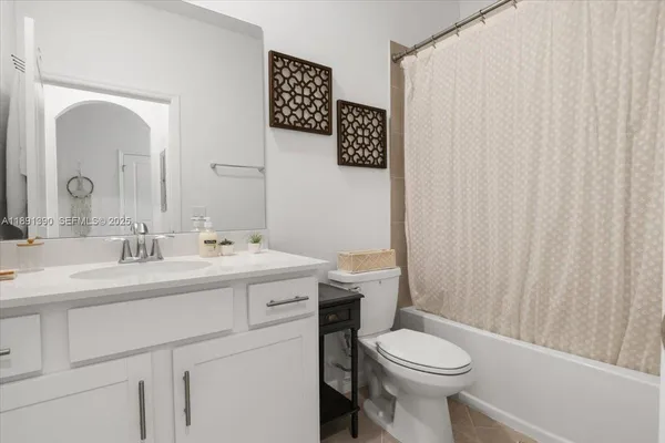 a bathroom with a toilet sink vanity and mirror