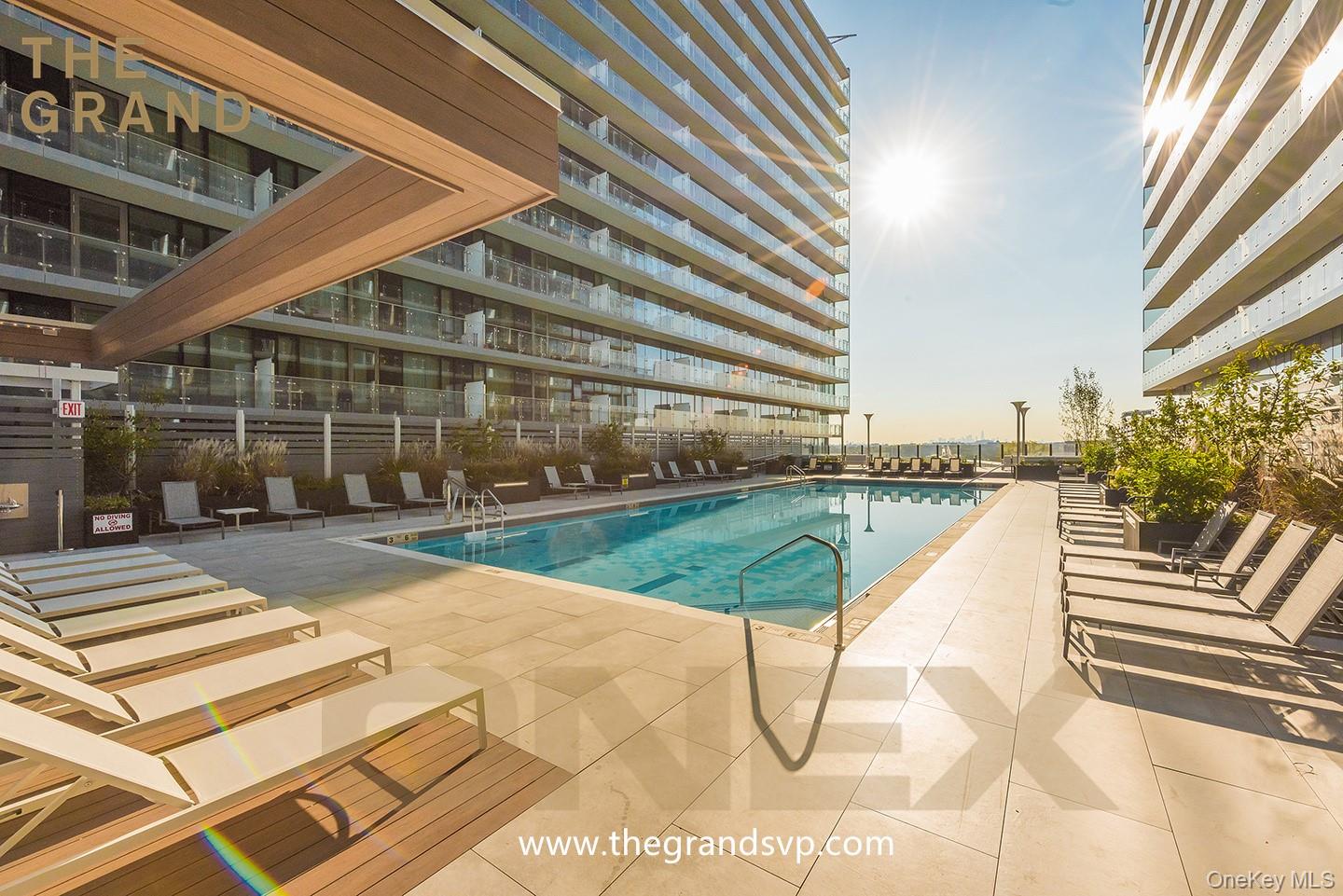 131-01 40 Road, Unit 16T Queens, NY 11354 - Photo 13 of 14 a view of a swimming pool with a lounge chairs