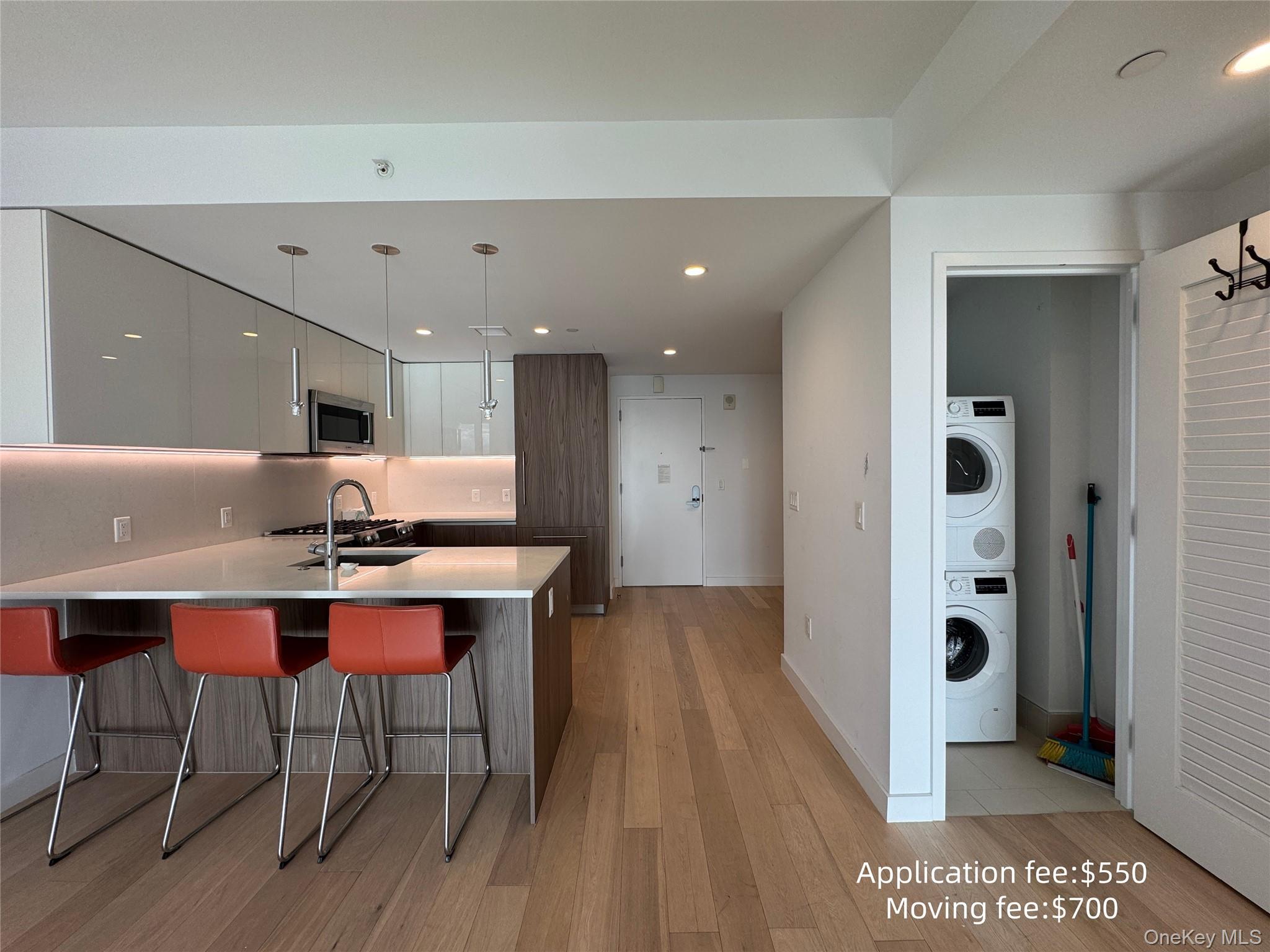 131-01 40 Road, Unit 16T Queens, NY 11354 - Photo 2 of 14 a room with stainless steel appliances kitchen island granite countertop a table chairs sink and wooden floor