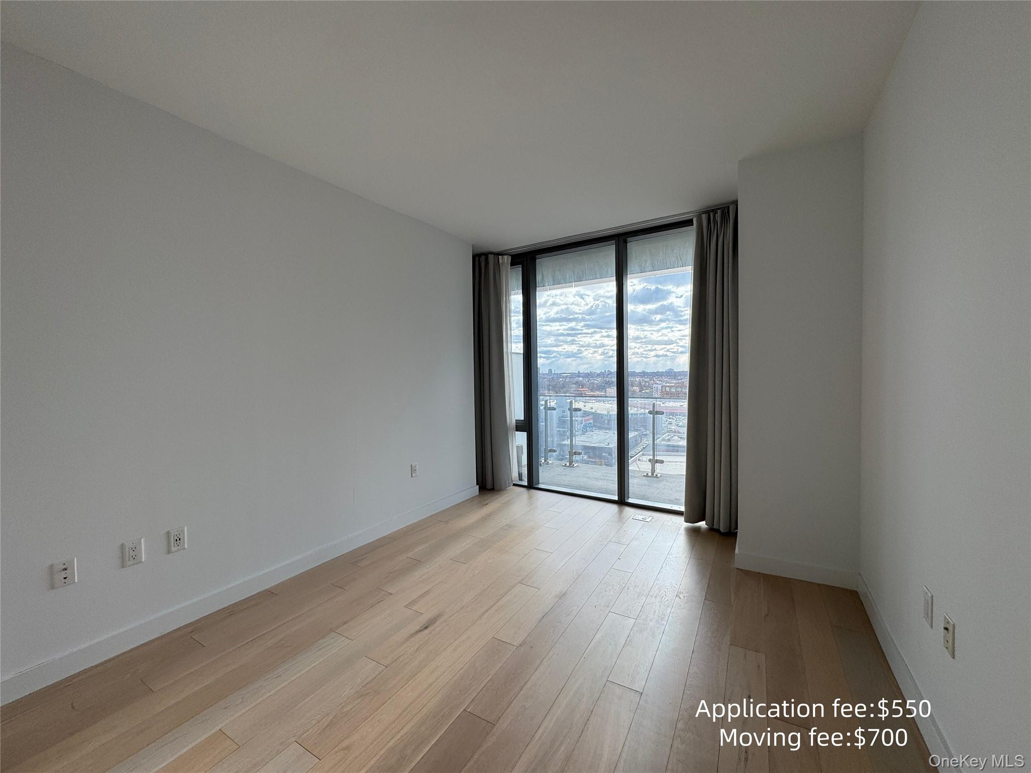 131-01 40 Road, Unit 16T Queens, NY 11354 - Photo 7 of 14 wooden floor in an empty room with a window