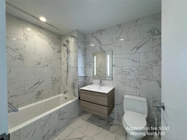 a bathroom with a sink toilet a mirror and bathtub