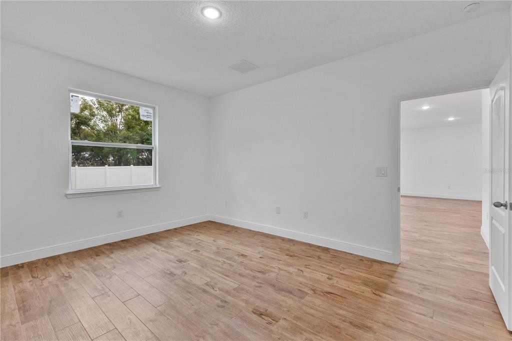 1425 River Road St. Cloud, FL 34769 - Photo 11 of 32 wooden floor in an empty room with a window