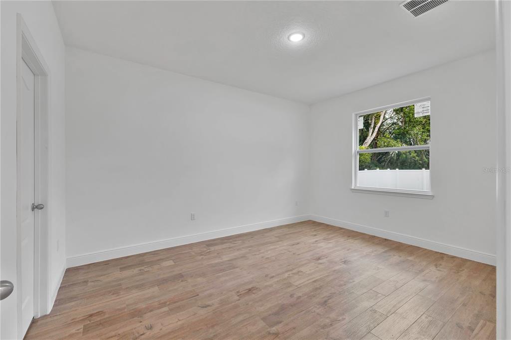 1425 River Road St. Cloud, FL 34769 - Photo 12 of 32 an empty room with wooden floor and windows