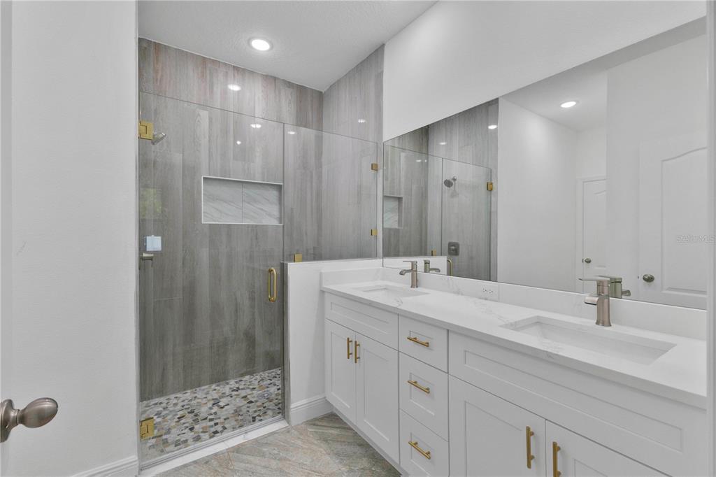 1425 River Road St. Cloud, FL 34769 - Photo 13 of 32 a bathroom with a double vanity sink mirror and shower