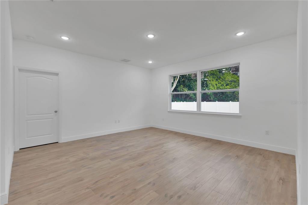 1425 River Road St. Cloud, FL 34769 - Photo 7 of 32 an empty room with wooden floor and windows