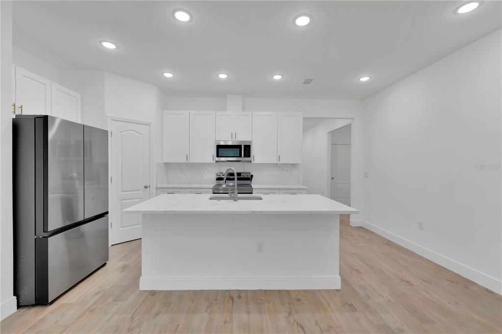 1425 River Road St. Cloud, FL 34769 - Photo 9 of 32 a view of kitchen with stainless steel appliances granite countertop a refrigerator a sink and a stove
