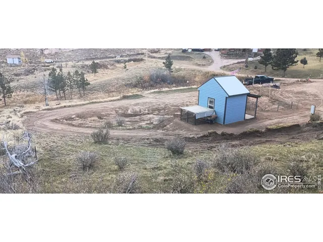 a view of a dry yard with wooden fence
