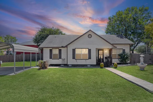 a front view of a house with a yard and trees