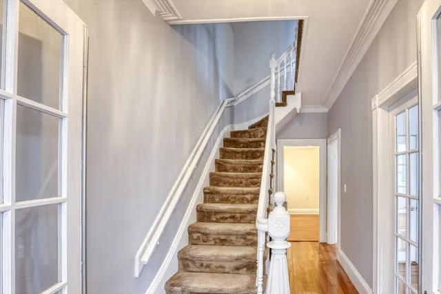 a view of staircase with wooden floor and white walls