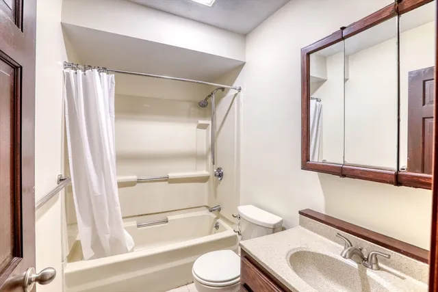 a bathroom with a granite countertop sink toilet and shower