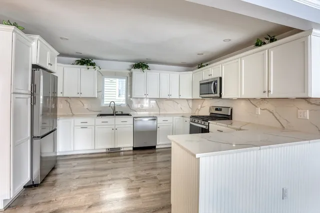 a kitchen with stainless steel appliances granite countertop a refrigerator sink and microwave