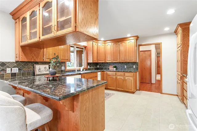 a kitchen with stainless steel appliances granite countertop a sink a stove and a refrigerator