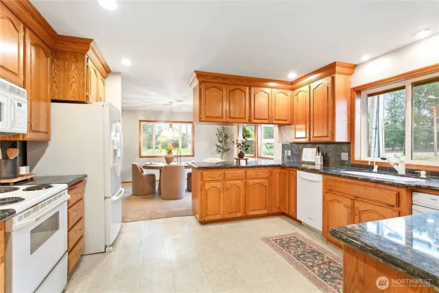 a kitchen with stainless steel appliances granite countertop a stove a sink and a microwave